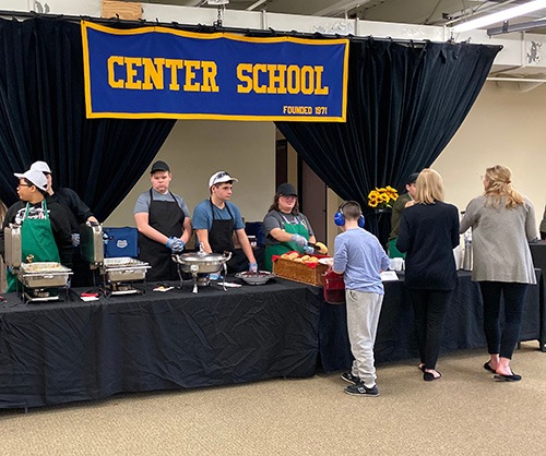 Center School students serving other students at a buffet line at the school