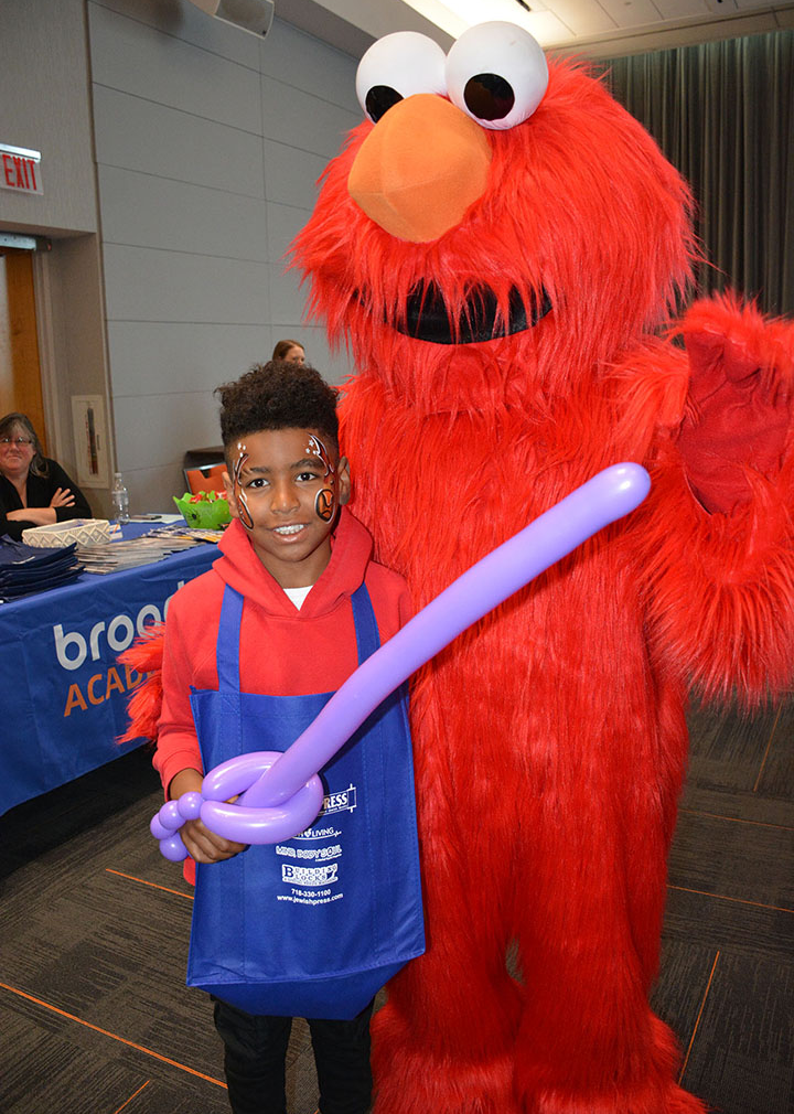 Elmo with a young male student event attendee